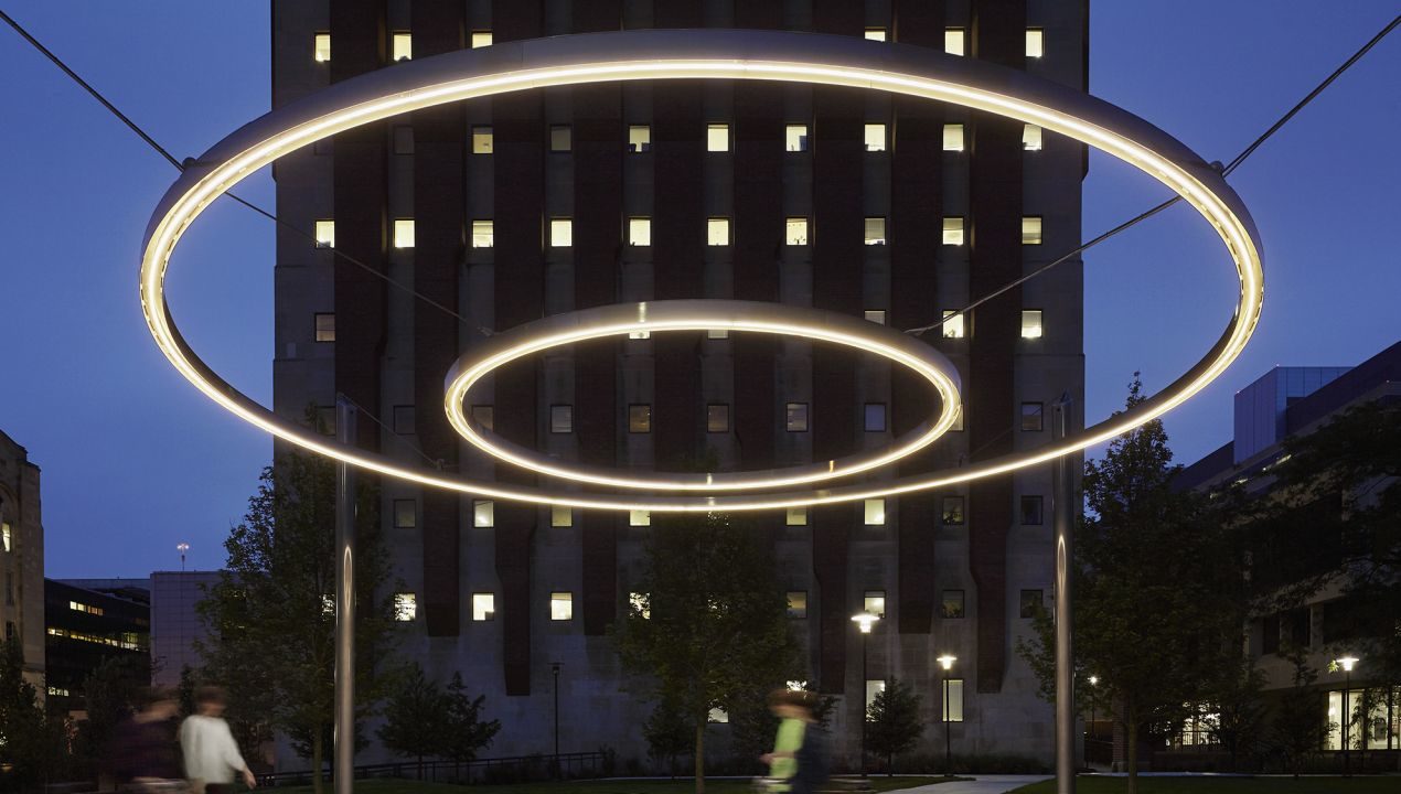 013 Jacobs Ryan Crerar Quad UChicago 2018 Circle of light suspended in sky with building behind