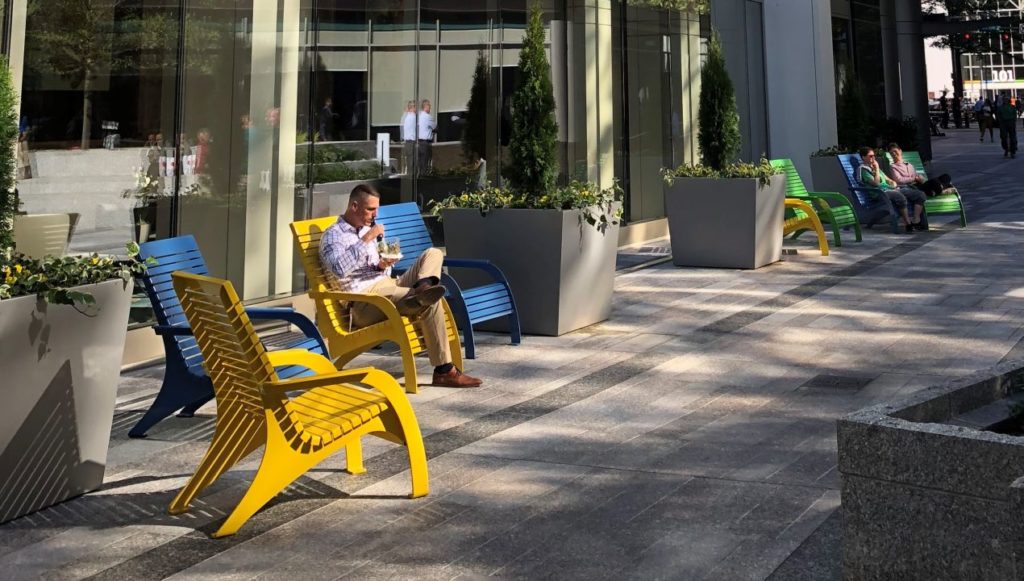 BOA-720Chairs man sitting in yellow outdoor chair in front of an office building