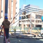 Construction workers lifting two circles into the air