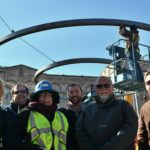 A group of people in the foreground smiling with the circle of light