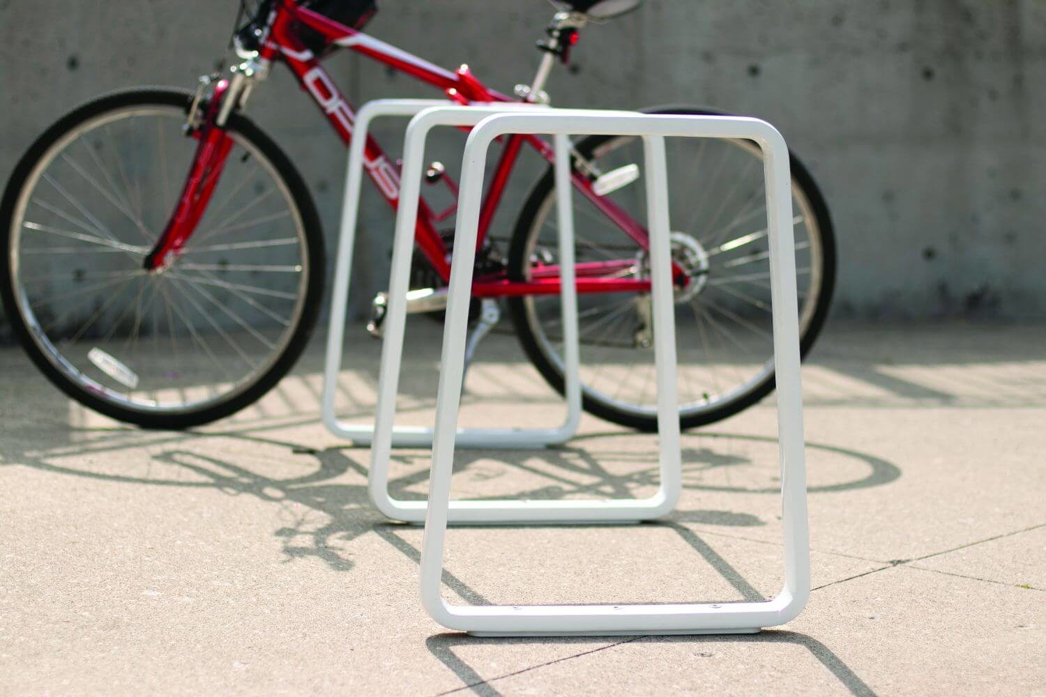 Iconic Bike Racks White Iconic bike rack with a red bike behind it