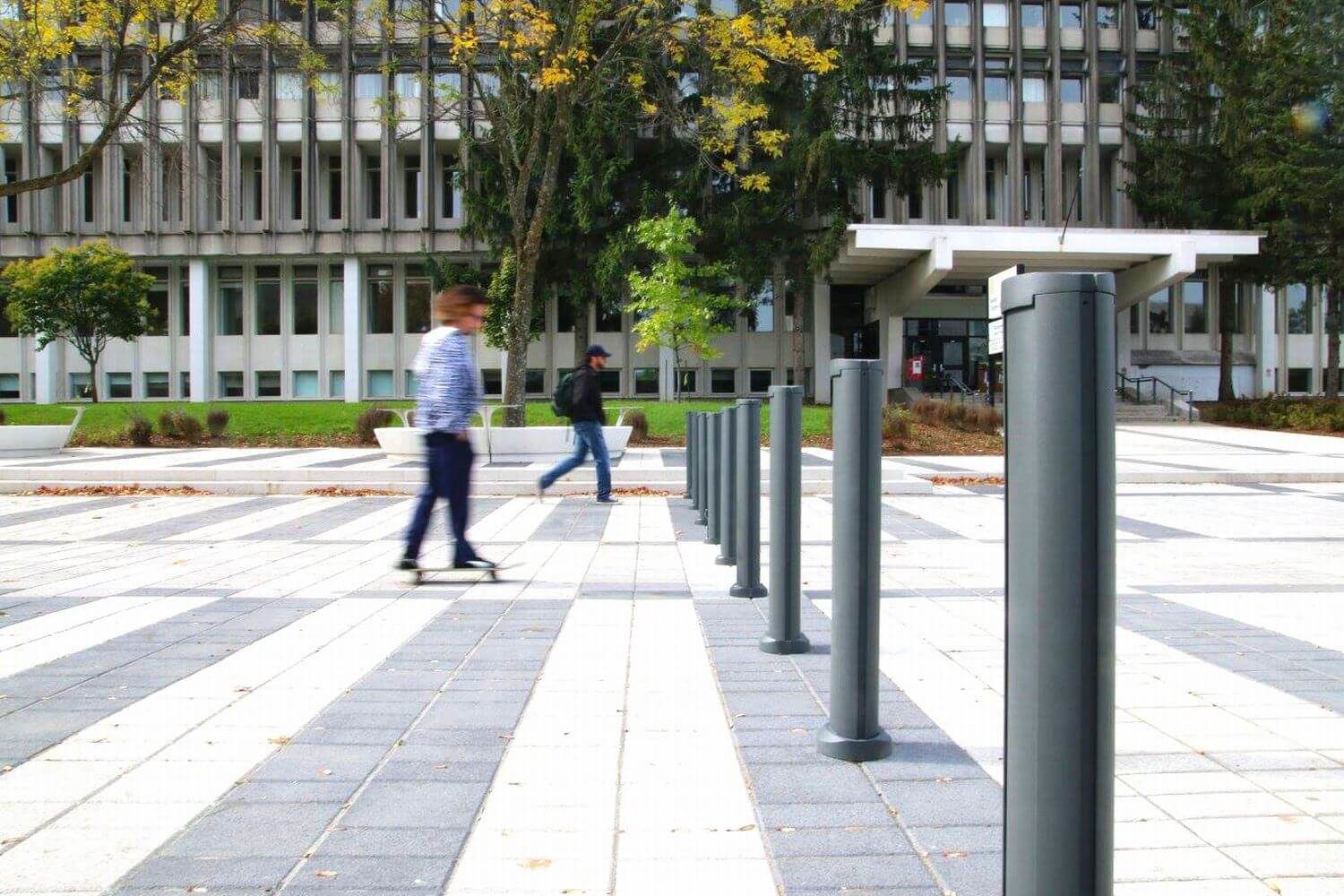 HOME_INSTALLATIONS_BOLLARDS__Universite de Laval_SC Bollards Bollards outside Laval University with man walking