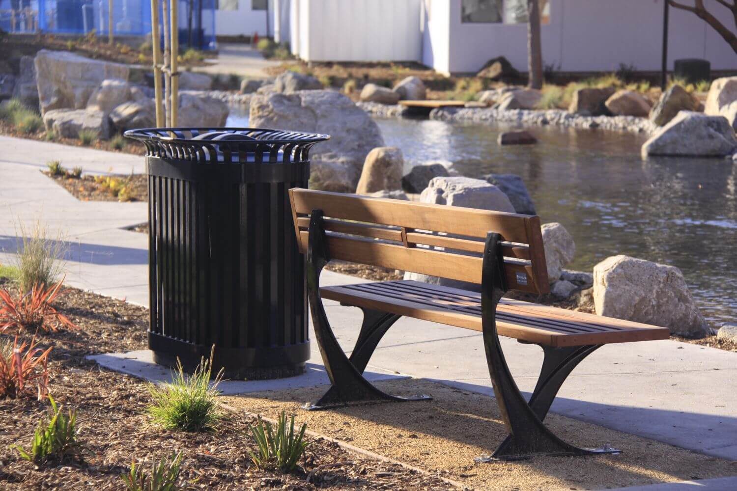 HOME_INSTALLATIONS_WASTE & RECYCLING_Lakeside Village Apartments_200 Trash - 2 Stream Wooden Bench and Black Bin