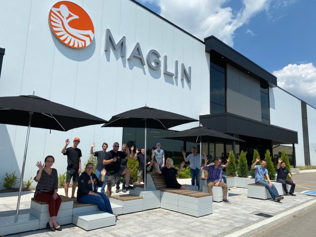 Group of people in front of a building waving at camera