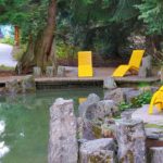 Three yellow chairs overlooking a pond