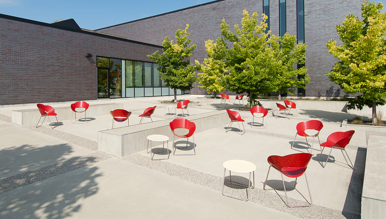Red Battery Lounge Chairs beside White Tables Outside of Building