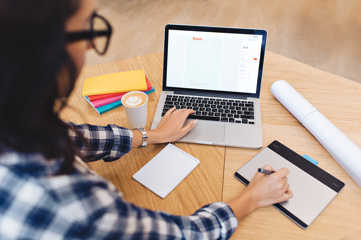 Modern work image young brunette woman in black glasses from back working with laptop on table. Creativity, graphic design, clever student, studying, freelancer. Women working on her laptop sitting at a table
