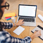 Women working on her laptop sitting at a table