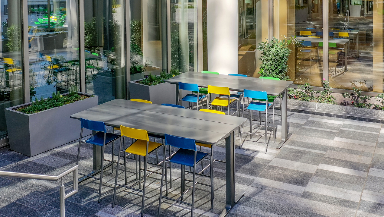 Blue and yellow bar height stools with ancora tables at Bank of America plaza