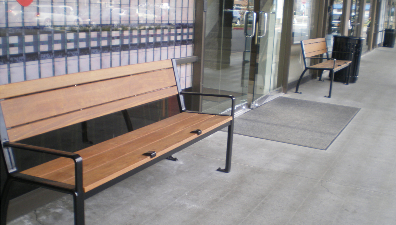 Two wood benches outside entrance to building