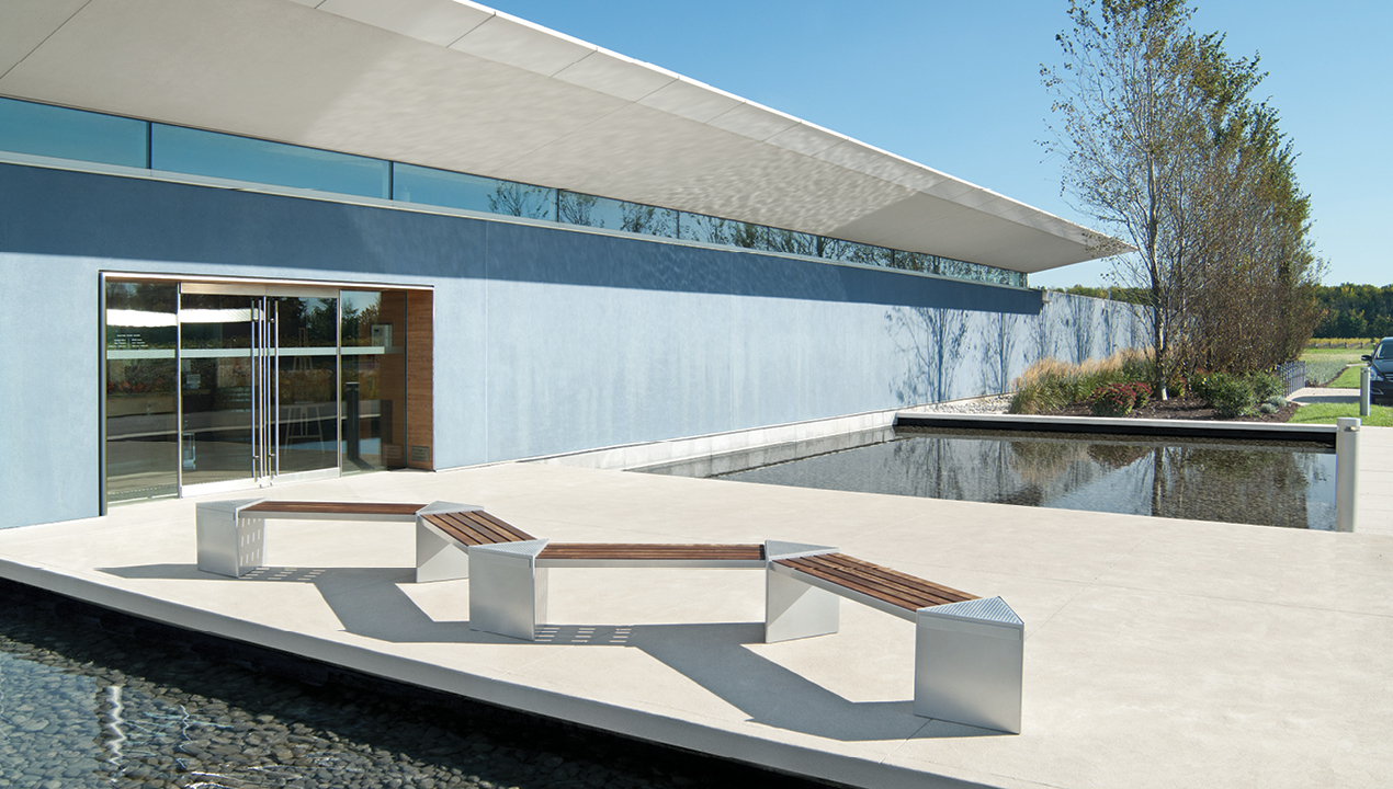 Zig zag Lexicon benches with triangular modules in front of blue building and water