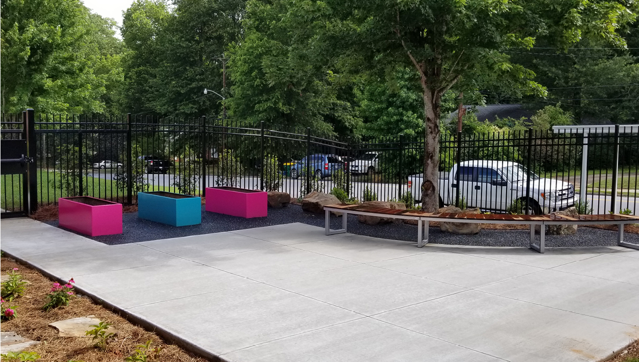 Pink and Blue Planters near Black Fence and Curved Bench Outside