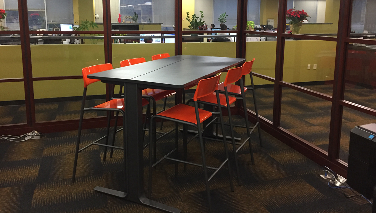 Table inside office with six orange chairs
