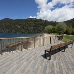 Two wood benches overlook mountains and a lake