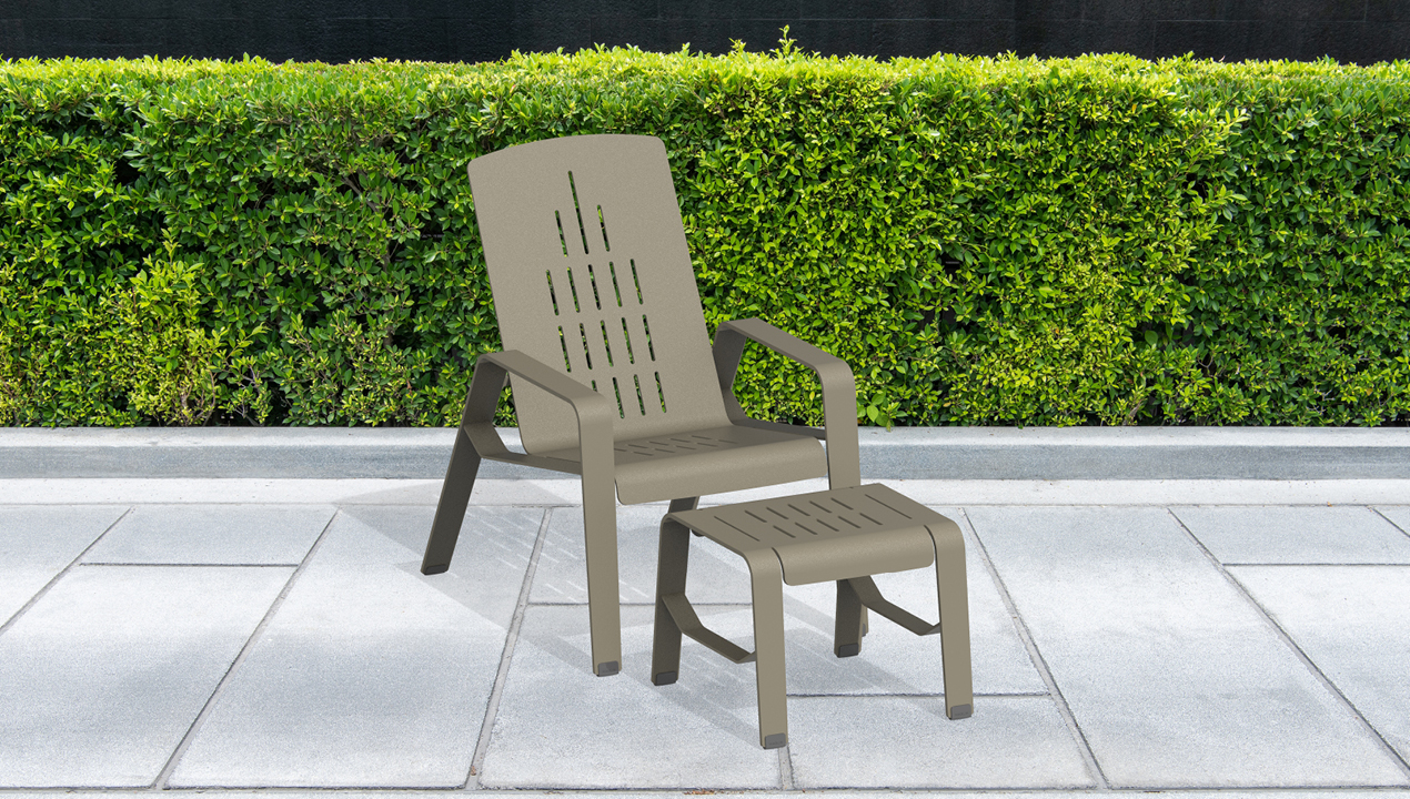 2700 Series - ALUM Lounge Chair and Footrest painted FineTex Titanium in front of green hedges