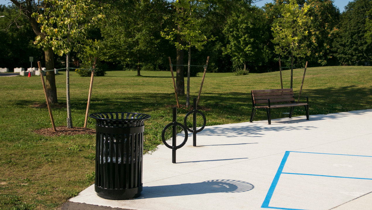200 Series Trash Receptacle with bike racks and Iconic bench at park