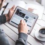 Guy reading Maglin product news on tablet with coffee
