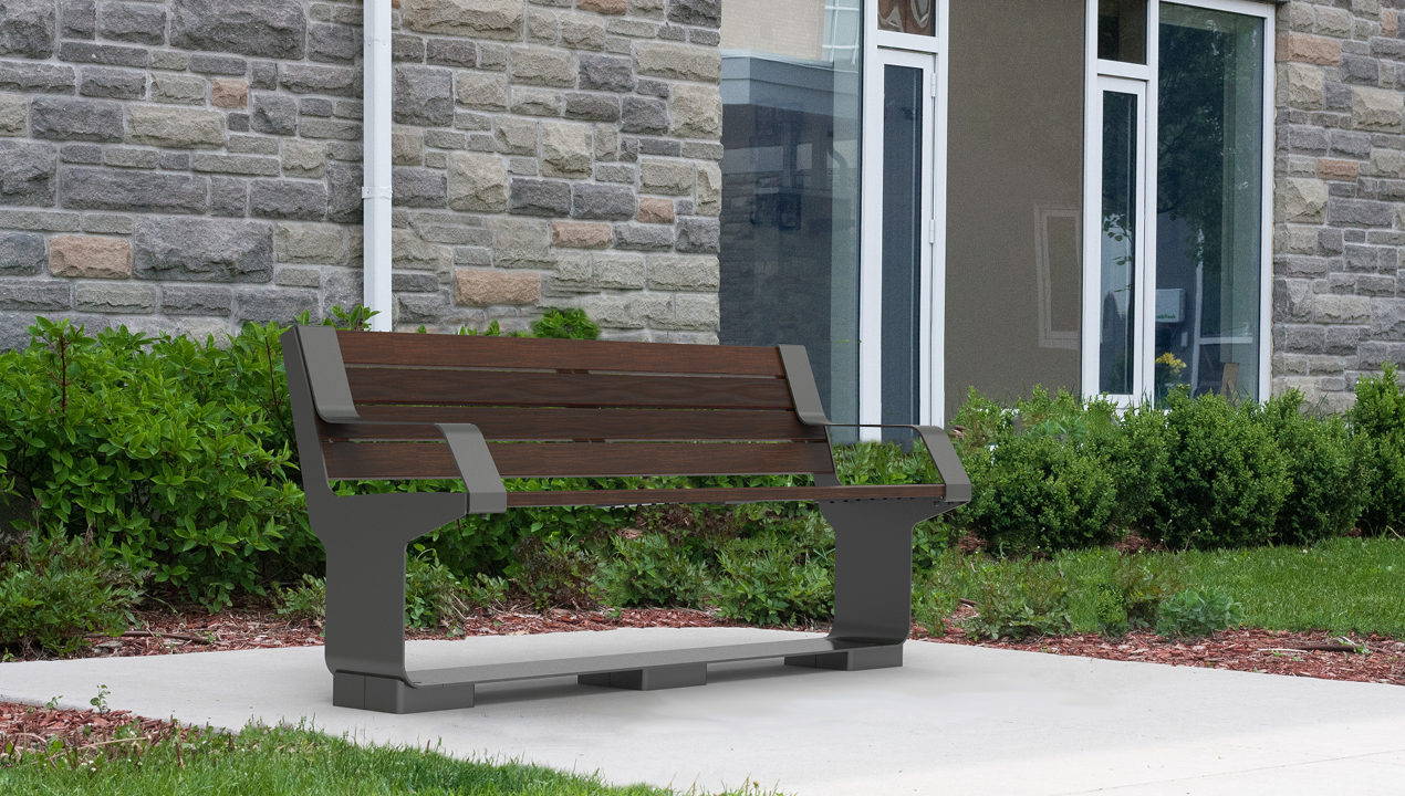L-Series Backed Bench with Arms, Wood, next to stone building
