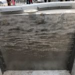 Close-up view of perforated metal screen with a pattern of clouds.