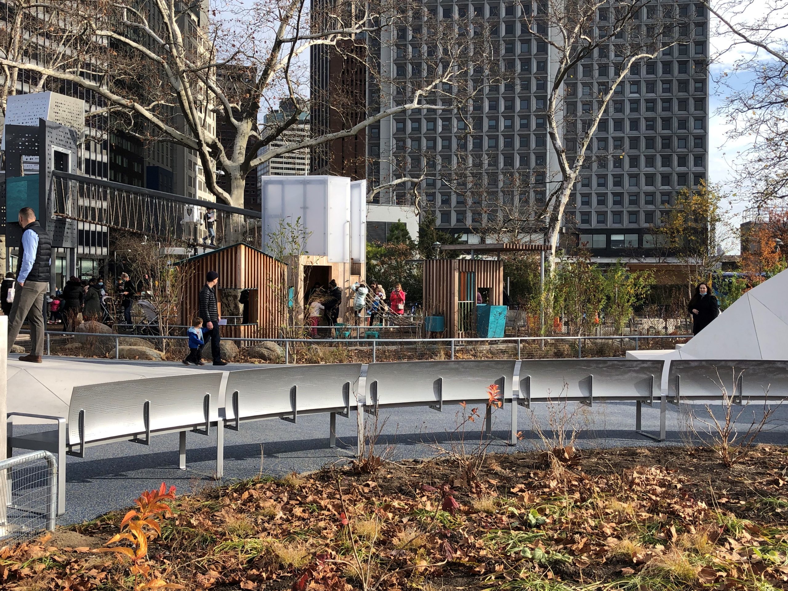 NY_Battery Playscape_custom-bench Back of custom perforated bench in foreground in front of playground