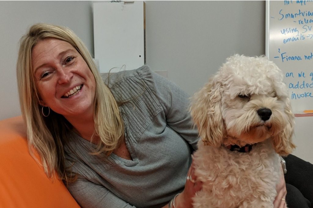 Jill-Roberts Jill smiling with a cute puppy at work