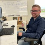 Oskar enjoying a coffee while working at his desk