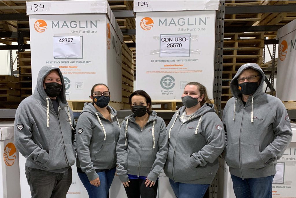 production-team Aaron, Erin, Sarah, Trish and Ian wearing matching hoodies in the plant