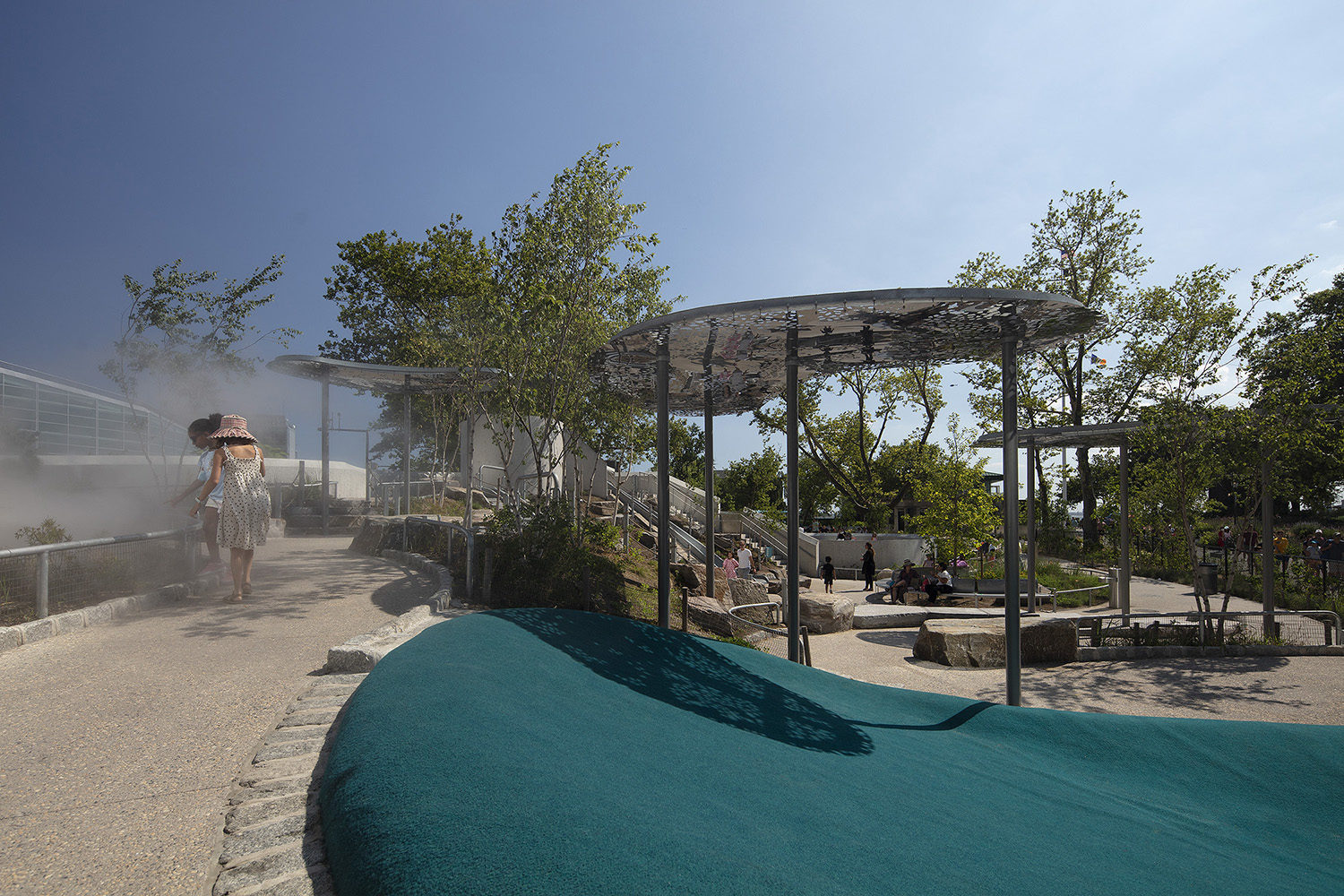 Children play in a mist feature at the Battery Playscape in New York City.