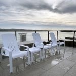 Set of 3 white Alum lounge chairs with lounge tables on the rooftop of Stewart McKelvey in Halifax.