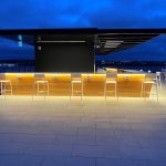 White Foro stools are lined up next to the bar on the rooftop terrace of Stewart McKelvey