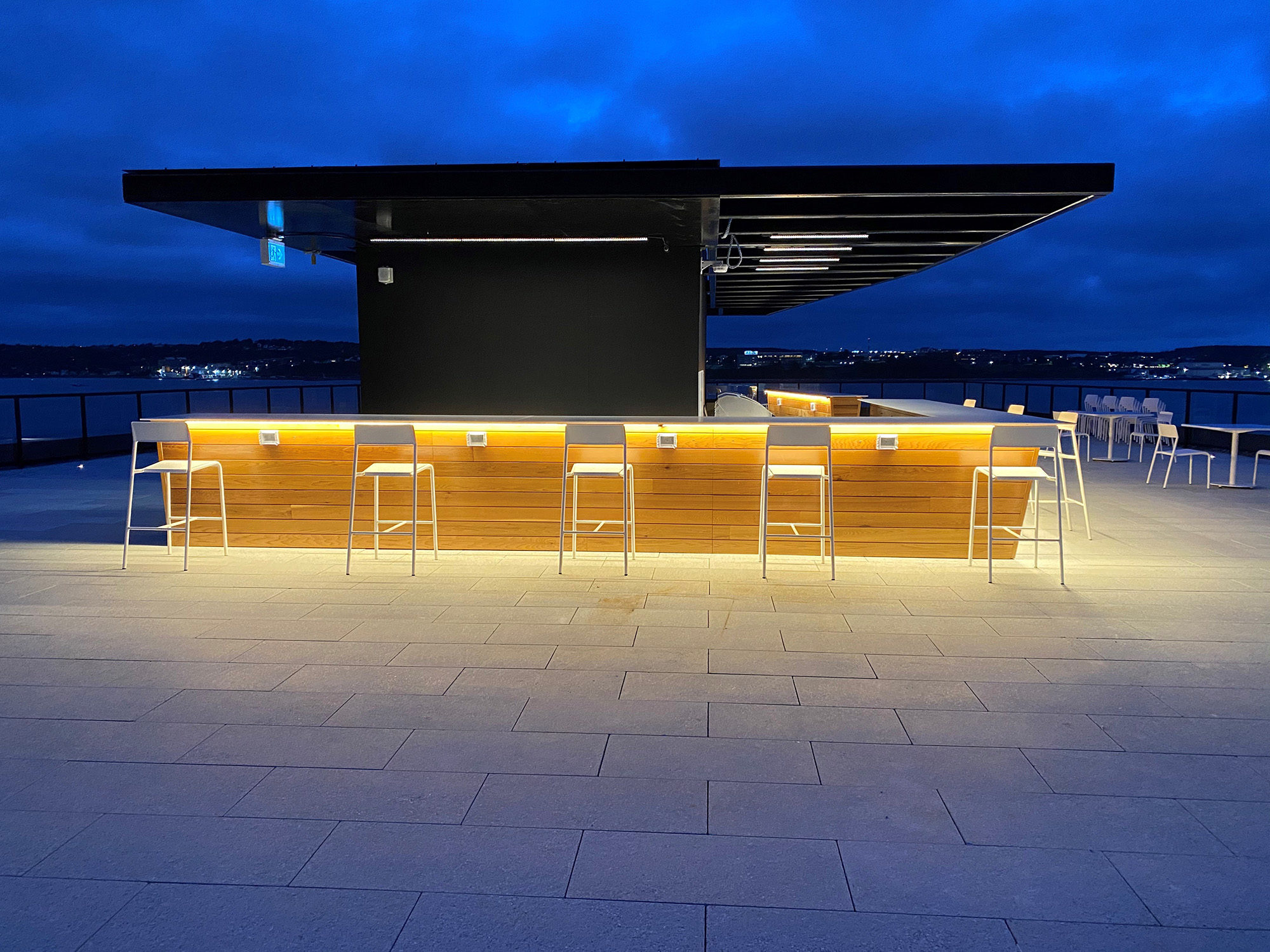 White Foro stools are lined up next to the bar on the rooftop terrace of Stewart McKelvey