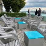 720 Chairs with Pixel Block cocktail tables in the foreground, people in the background enjoying the view at Viridian Apartments in Boston.