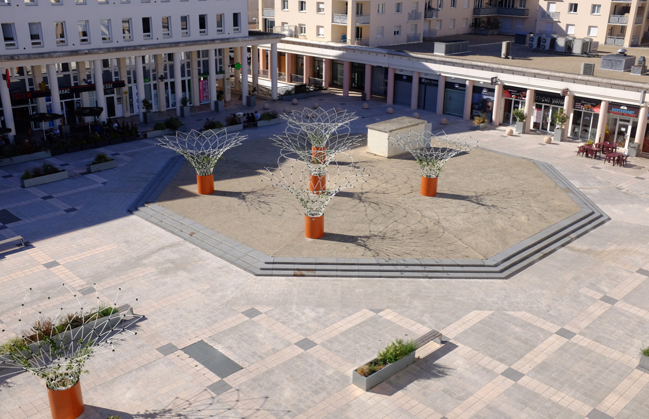 Urban Canopee Corolle's powdercoat orange standard planters on concrete in outdoor space