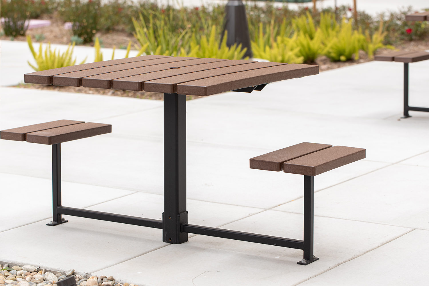 Maglin two-seat 400 Series cluster seating unit is installed on concrete in an apartment amenity courtyard in Chula Vista, CA. The table is open on either side to allow mobility and wheeled accessible devices to engage with the table.