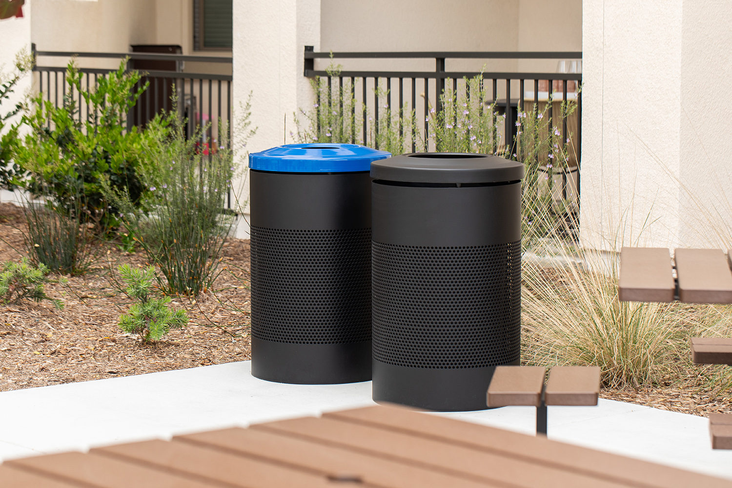 maglin_600-waste-recycling_400-cluster_otay-ranch-village_001 Maglin 600 Series black Recycling and Waste containers are placed in the amenity courtyard of an apartment in Chula Vista, CA. The recycling container has a blue lid to denote its purpose.