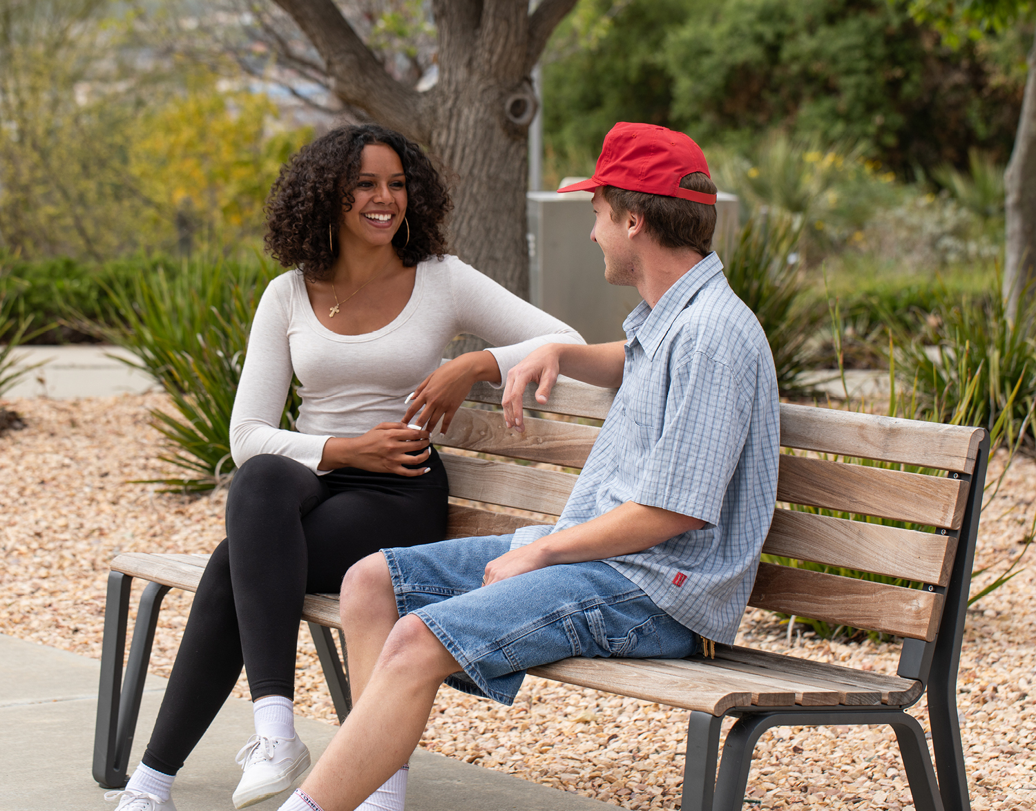 People enjoying conversation while sitting on a Maglin Iconic Backed Bench