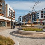 Several raised circular concrete planting beds offer seating with Ogden Benches wallmounted on top.