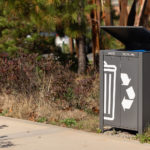 Lexicon waste and recycling unit along walkway with greenery in background