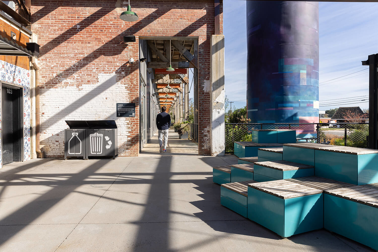 Man walking away from Maglin Pixel blocks and Lexicon waste and recycling at Camp North End