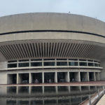 Concrete building with tables and seating next to waterway
