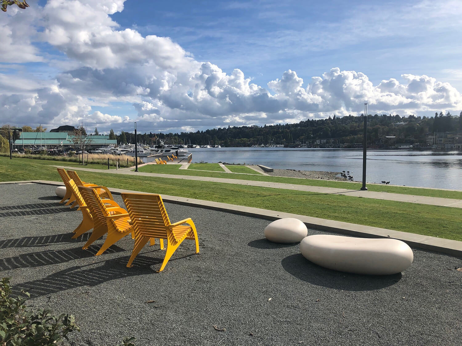 Cloudy bright blue skies with water and 720 Maglin yellow chairs