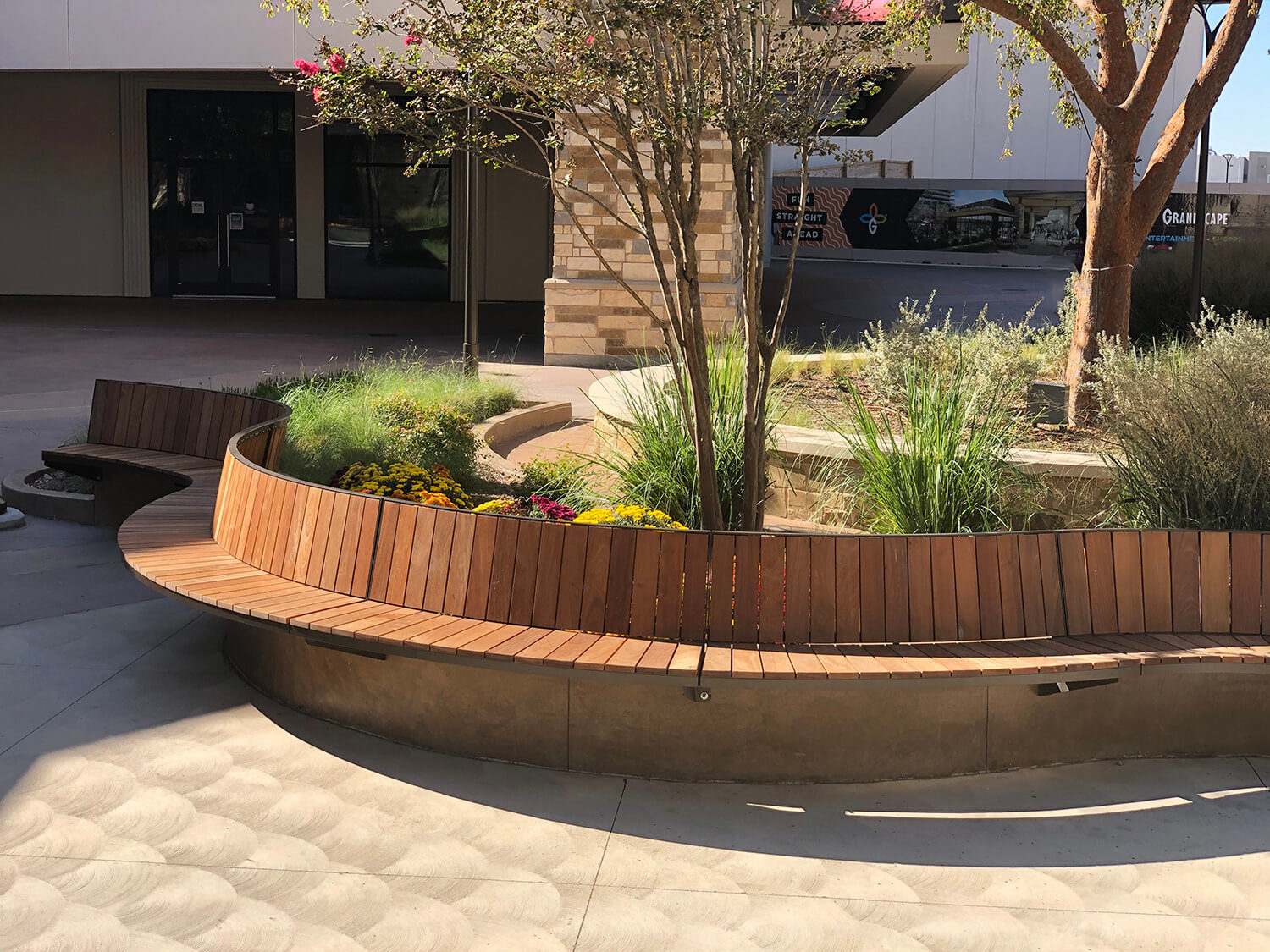Curved Ogden bench follows the concrete wall on outdoor patio