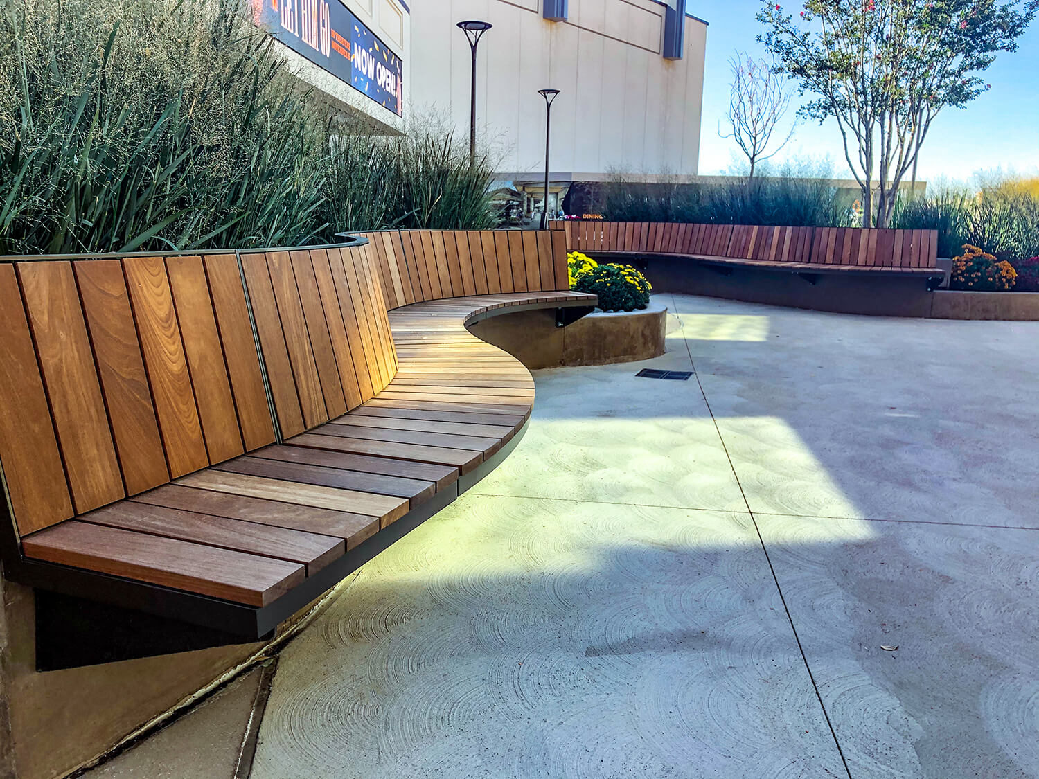 Curved Ogden cantilever benches surrounded by gardens and greenery at Grandscape