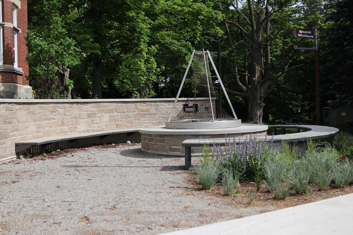 Curved Ogden benches surround fire pit at the University of Guelph - Lang Plaza