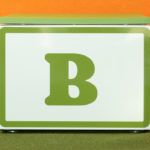 A large white block with a green letter