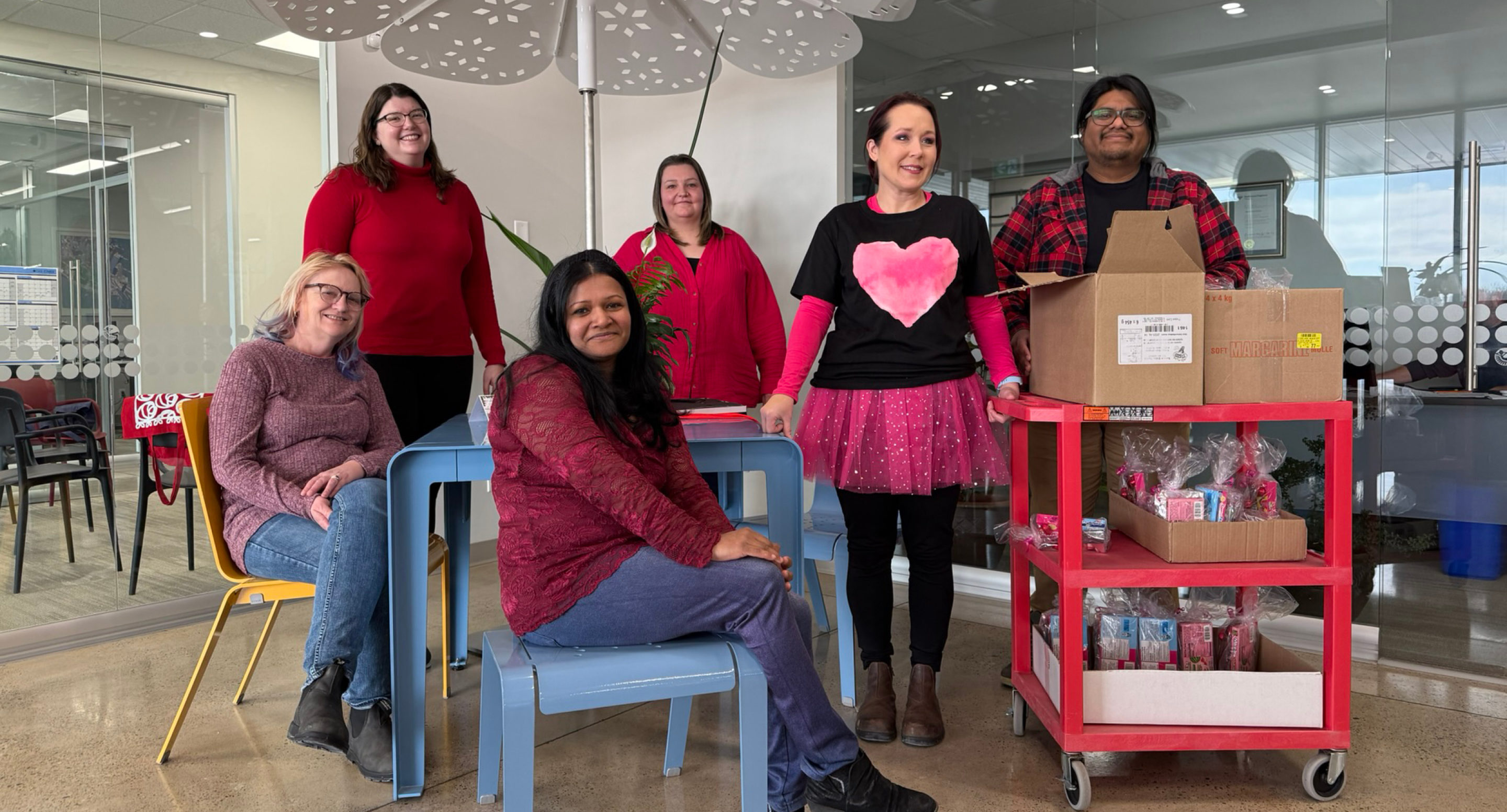 cheryl-elizabeth-usha-trish-sarah-edgar-valentines Maglin employees pose for a photo on Valentine's Day! Sarah wears a black t-shirt with a pink heart and Edgar has a tray of Valentine's Day goodies.