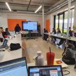 Maglin employees sit and listen to a presentation by product designer Edgar
