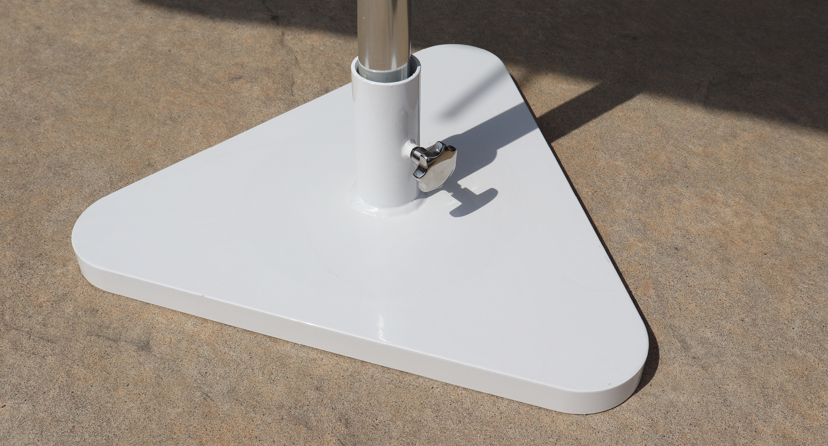 maglin-collections-kontur-gallery A close-up of a white triangular metal base supporting a vertical pole on a concrete surface.