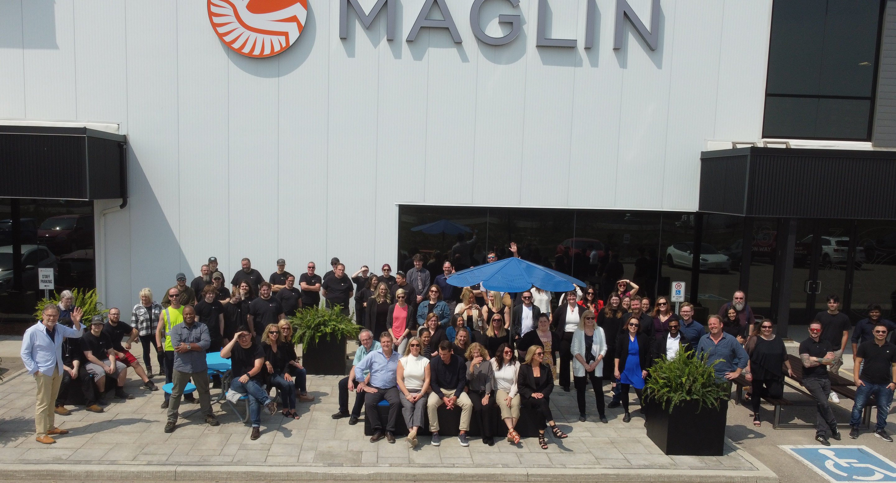 maglin-company-hero-img Maglin team posing outside Maglin head office on sunny day