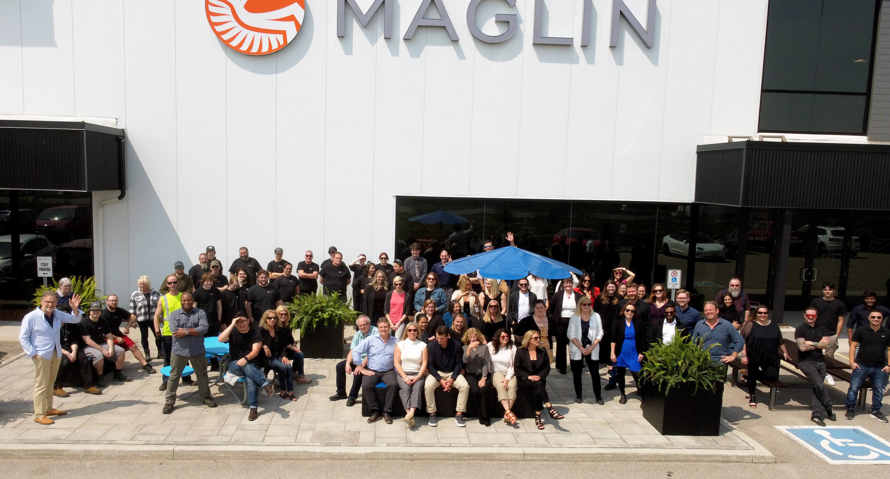A drone image of Maglin employees waving in front of the Maglin headquarters.